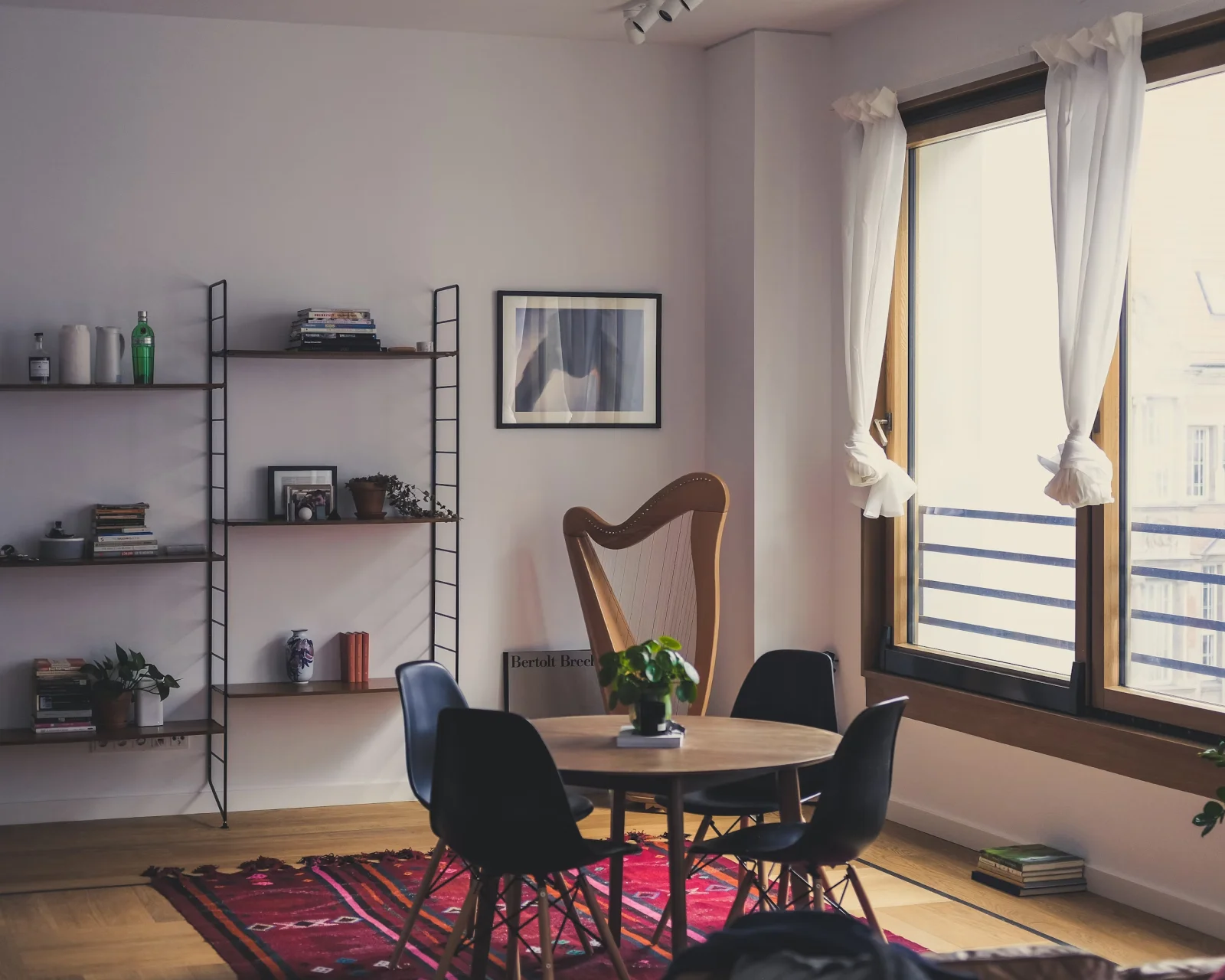 A room with a couch, table and chairs.